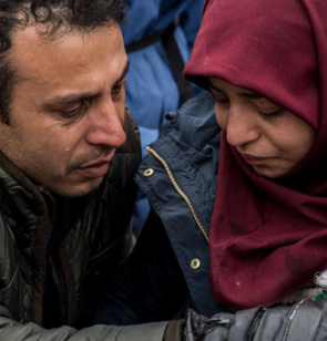 couple de réfugiés donnant à boire à leur bébé
