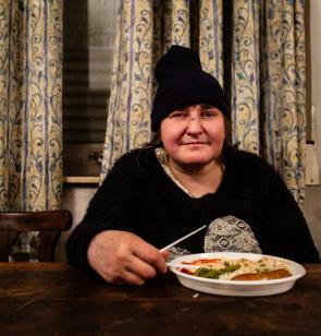 Dakloze vrouw krijgt een maaltijd in een noodopvang in Brussel. ©Kristof Vadino, 2016, Brussel.