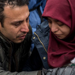 couple de réfugiés donnant à boire à leur bébé