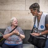 oude dame wordt geholpen door vrijwilliger op straat 