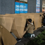 migrants devant des tentes en carton